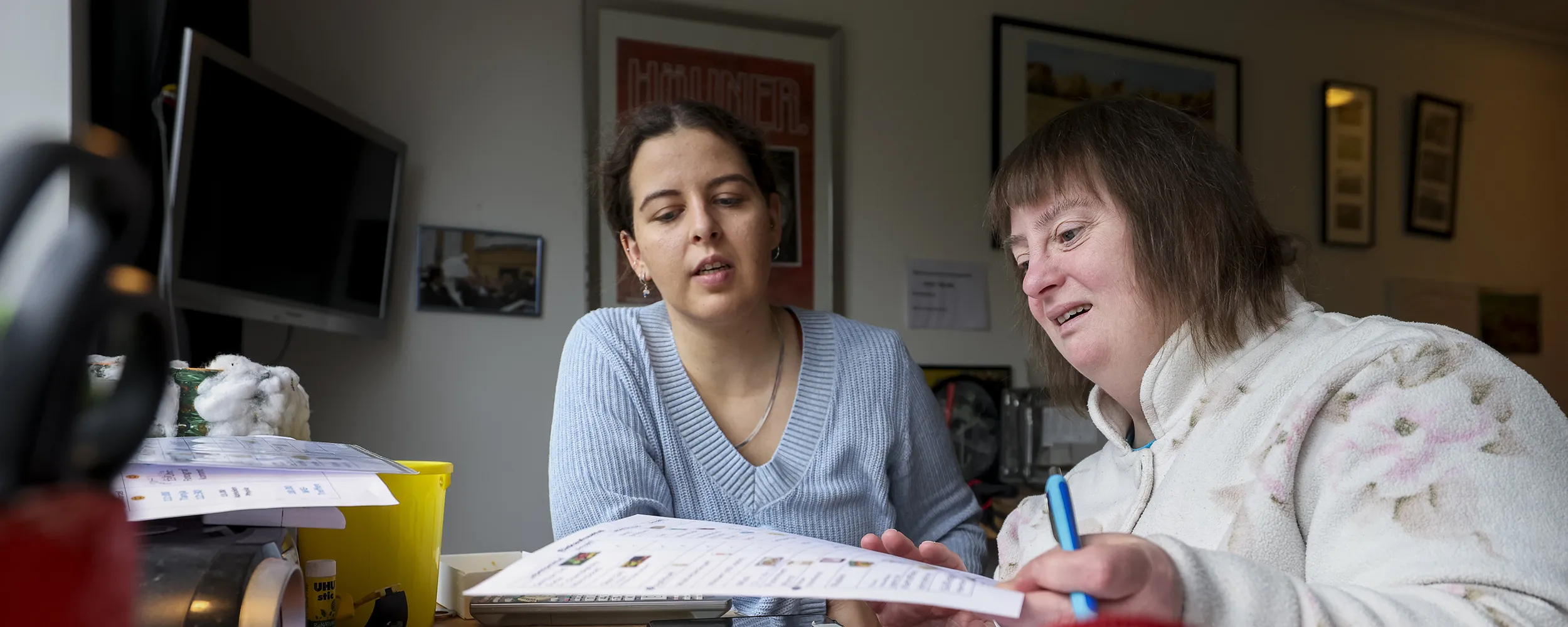 Zwei Frauen sitzen nebeneinander und unterhalten sich.