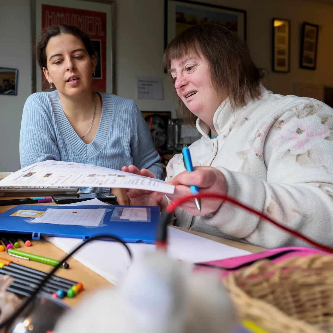 Zwei Frauen sitzen nebeneinander und unterhalten sich.